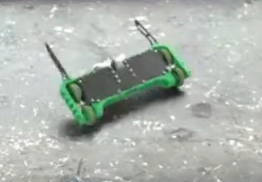 The robot driving across the arena, rear three-quarter view.