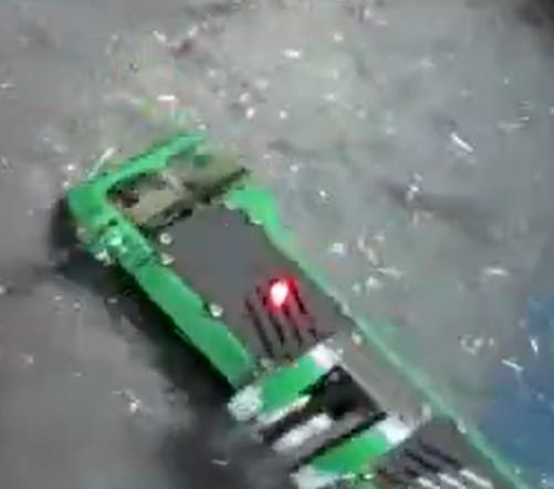 Oblique overhead view of the robot on a debris-covered arena floor.